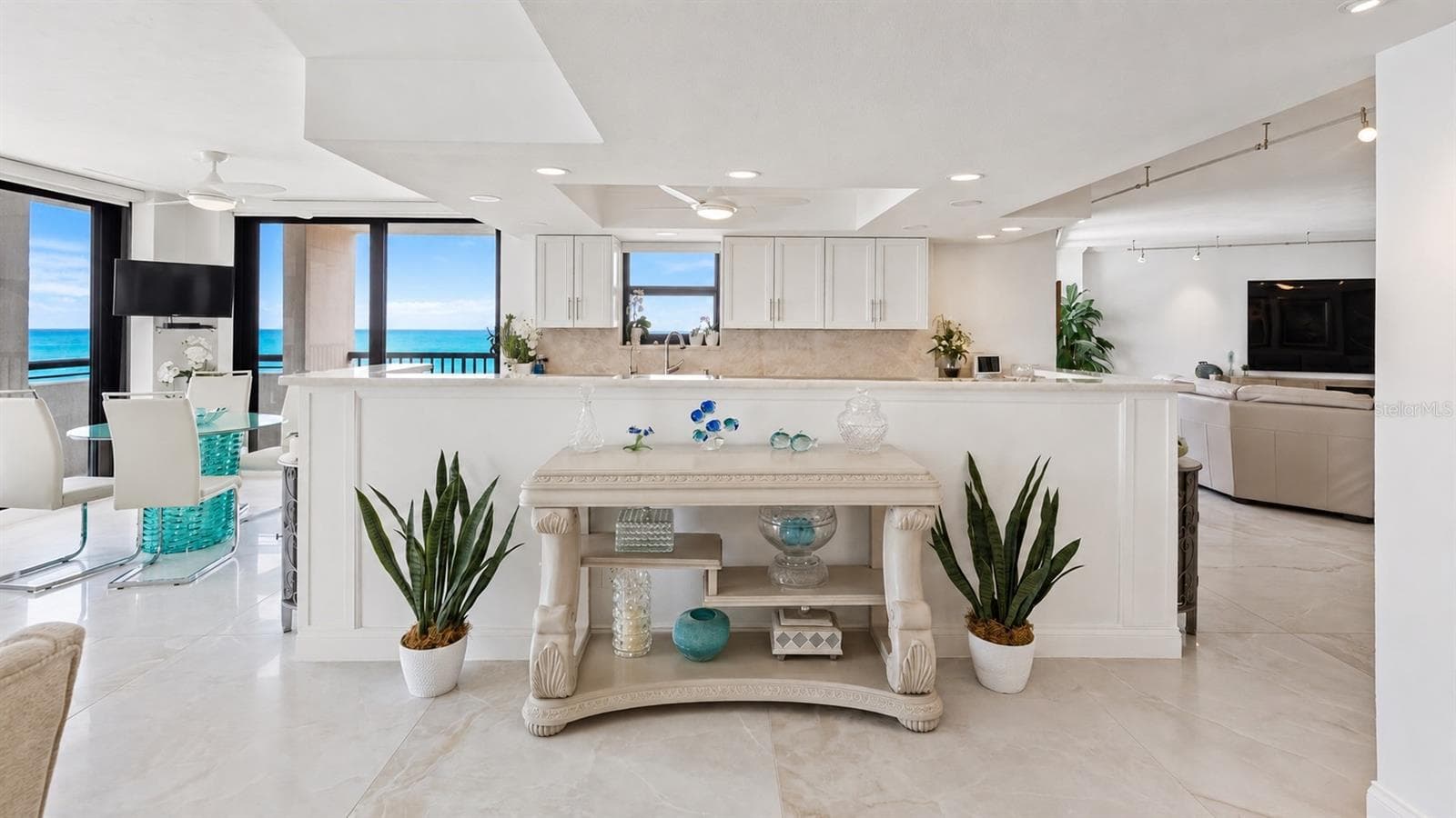 View from the dining area into the chef's kitchen with panoramic views of the sugar-sand beach and the gentle gulf waters beyond. - 1660 GULF BLVD #PH1, CLEARWATER BEACH