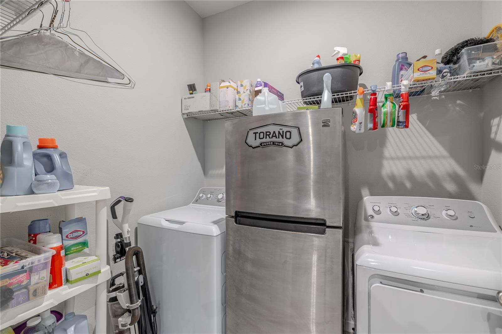 The dedicated laundry room offers space for full-size washer and dryer appliances, generous wire shelving and additional storage for everyday household essentials. - 3029 JACOB CROSSING LN, HOLIDAY