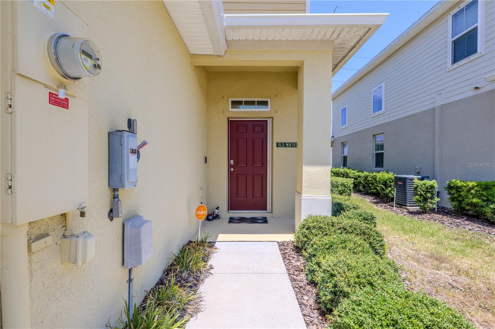 A covered side entry adds a welcoming touch to this end-unit townhome, with a landscaped walkway leading to the front door and a transom window bringing extra light into the foyer. - 3029 JACOB CROSSING LN, HOLIDAY