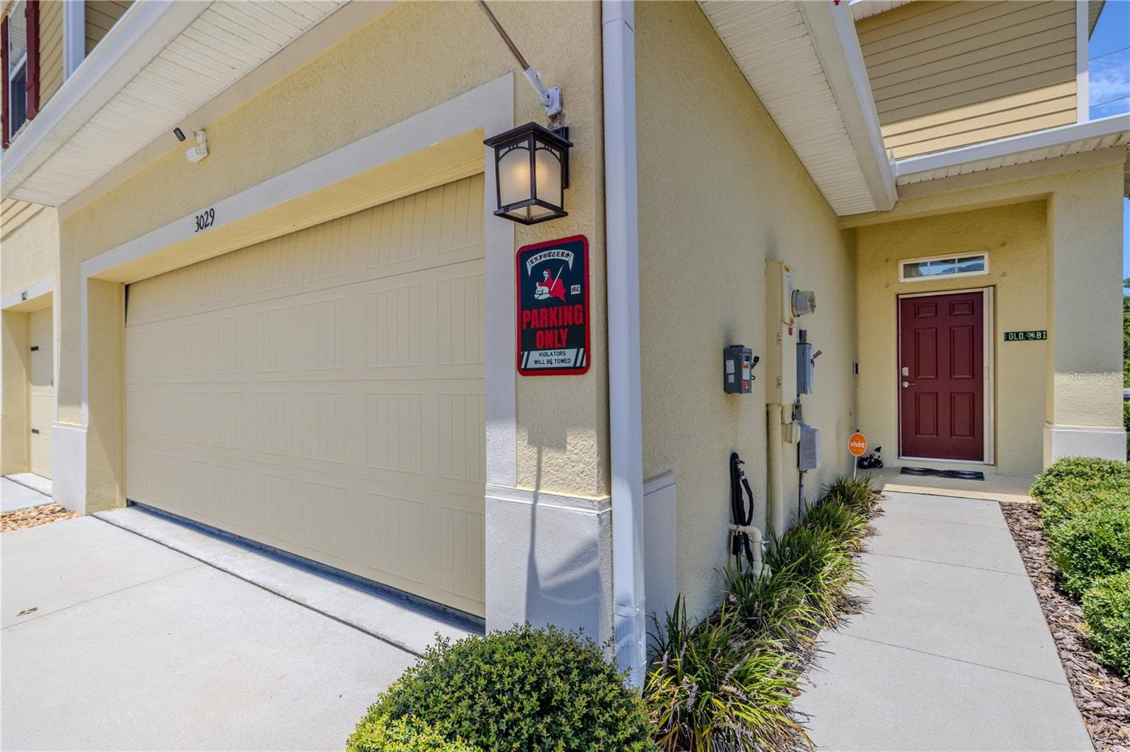 An attached 2-car garage and covered side entry give this end-unit townhome a polished arrival, with a landscaped walkway leading from the driveway to the front door. - 3029 JACOB CROSSING LN, HOLIDAY
