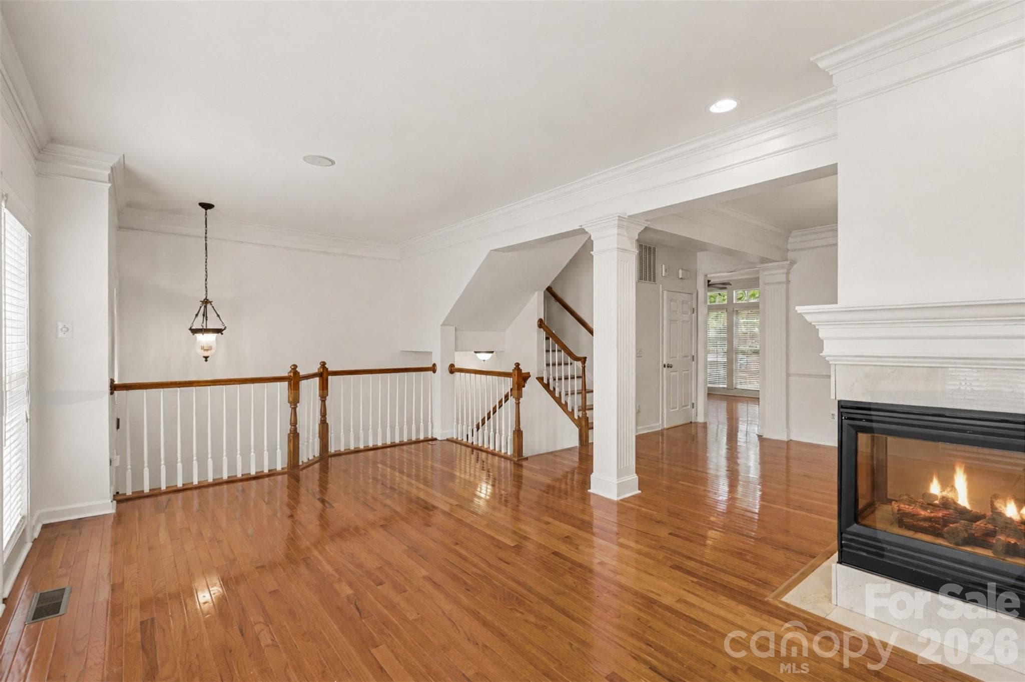 An open rail keeps sightlines to the floor above instead of boxing the living room in. - 3251 Luke Crossing Drive, Charlotte