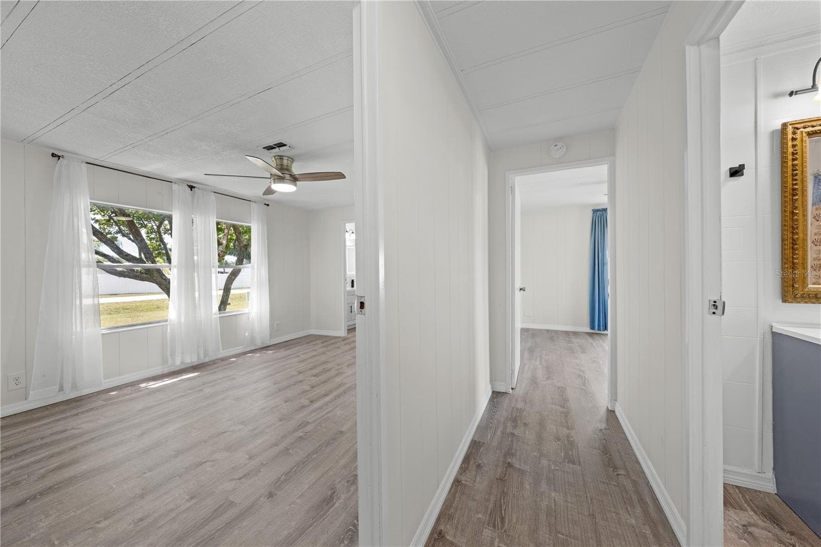 View towards the end of hallway. Primary bedroom on left, bedroom 3 in center and guest bathroom on right. - 5601 LAKE LIZZIE DR, ST CLOUD