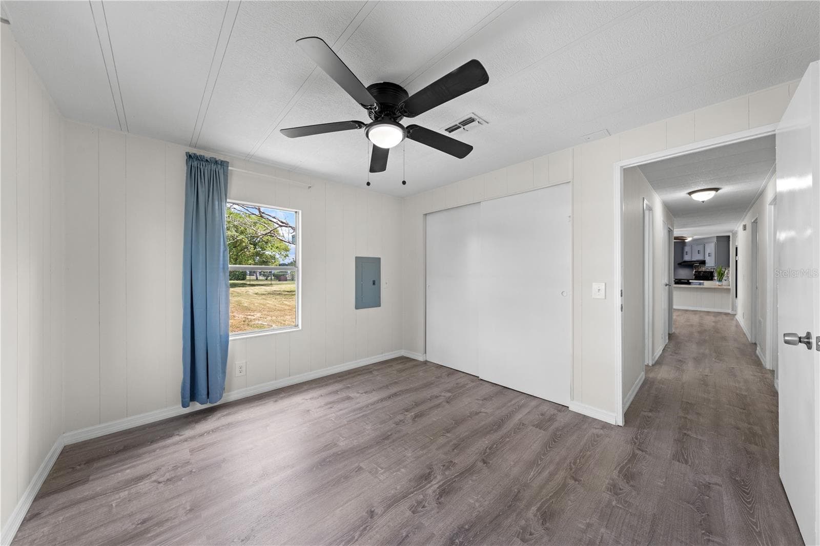 Bedroom 3 with a look back down the hallway and a back yard view. - 5601 LAKE LIZZIE DR, ST CLOUD