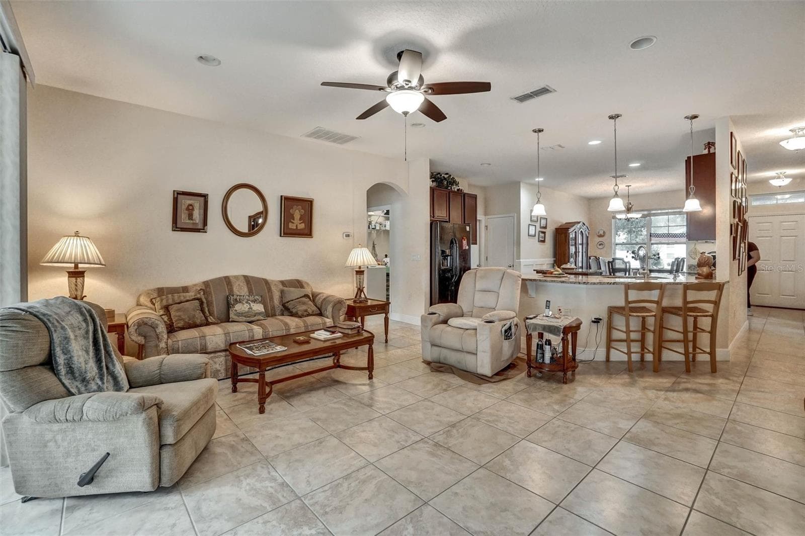 Open living area with comfortable seating and a seamless dinning room and kitchen connection - 1720 LADY FERN TRL, DELAND