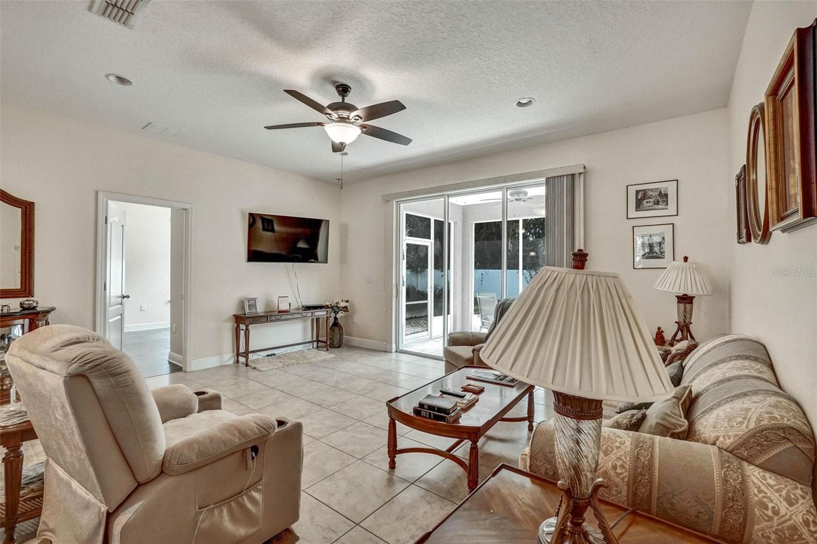 Living RoomSpacious living room with tile flooring and sliding glass doors. - 1720 LADY FERN TRL, DELAND