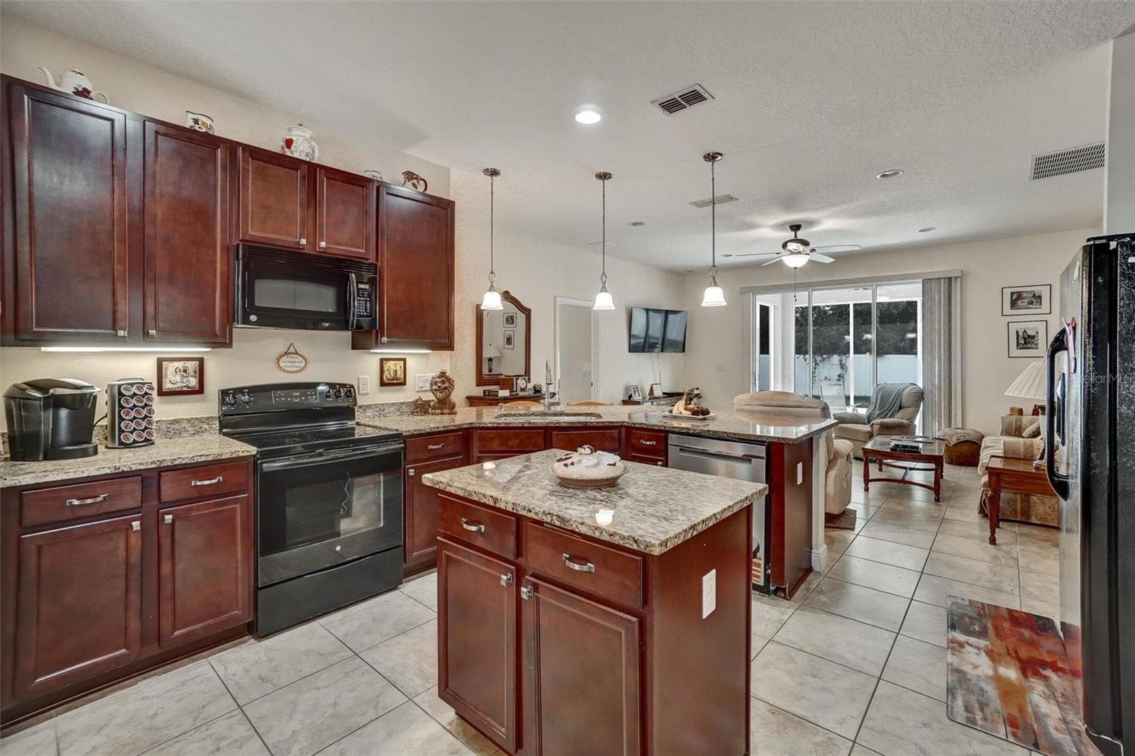 Kitchen IslandSpacious kitchen featuring granite countertops, wood cabinetry, and a center island. - 1720 LADY FERN TRL, DELAND