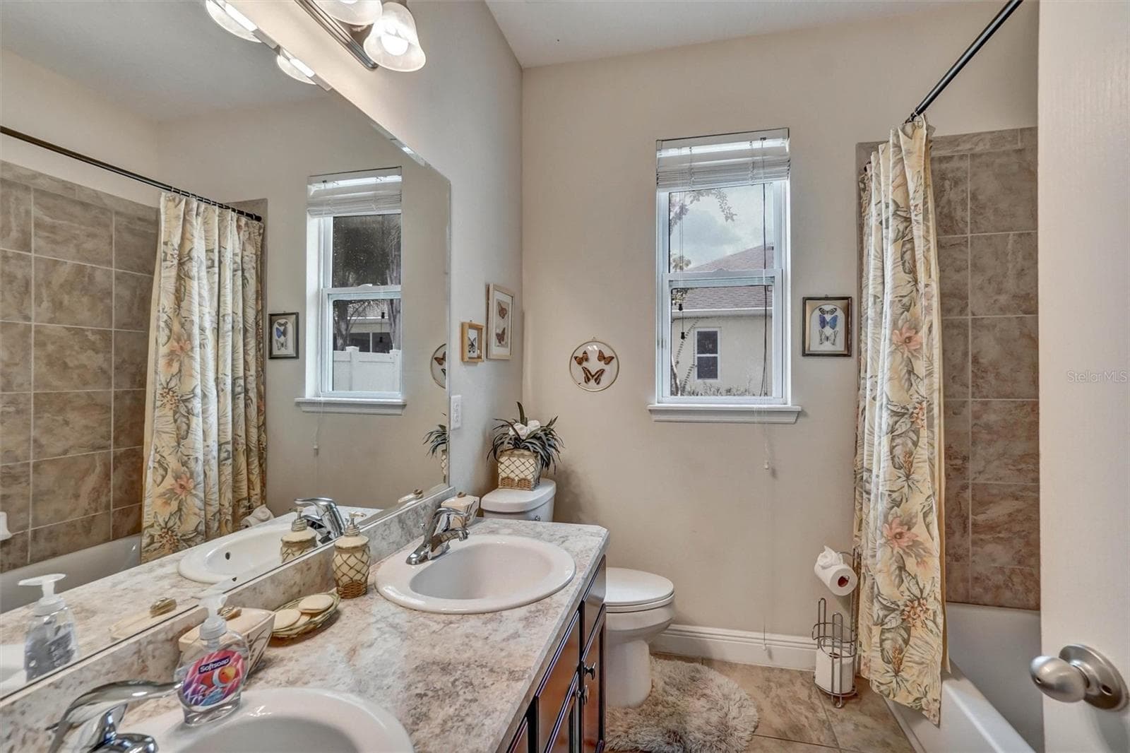 Second BathroomGuest bathroom featuring a spacious vanity, tiled walls, tub, and natural light. - 1720 LADY FERN TRL, DELAND