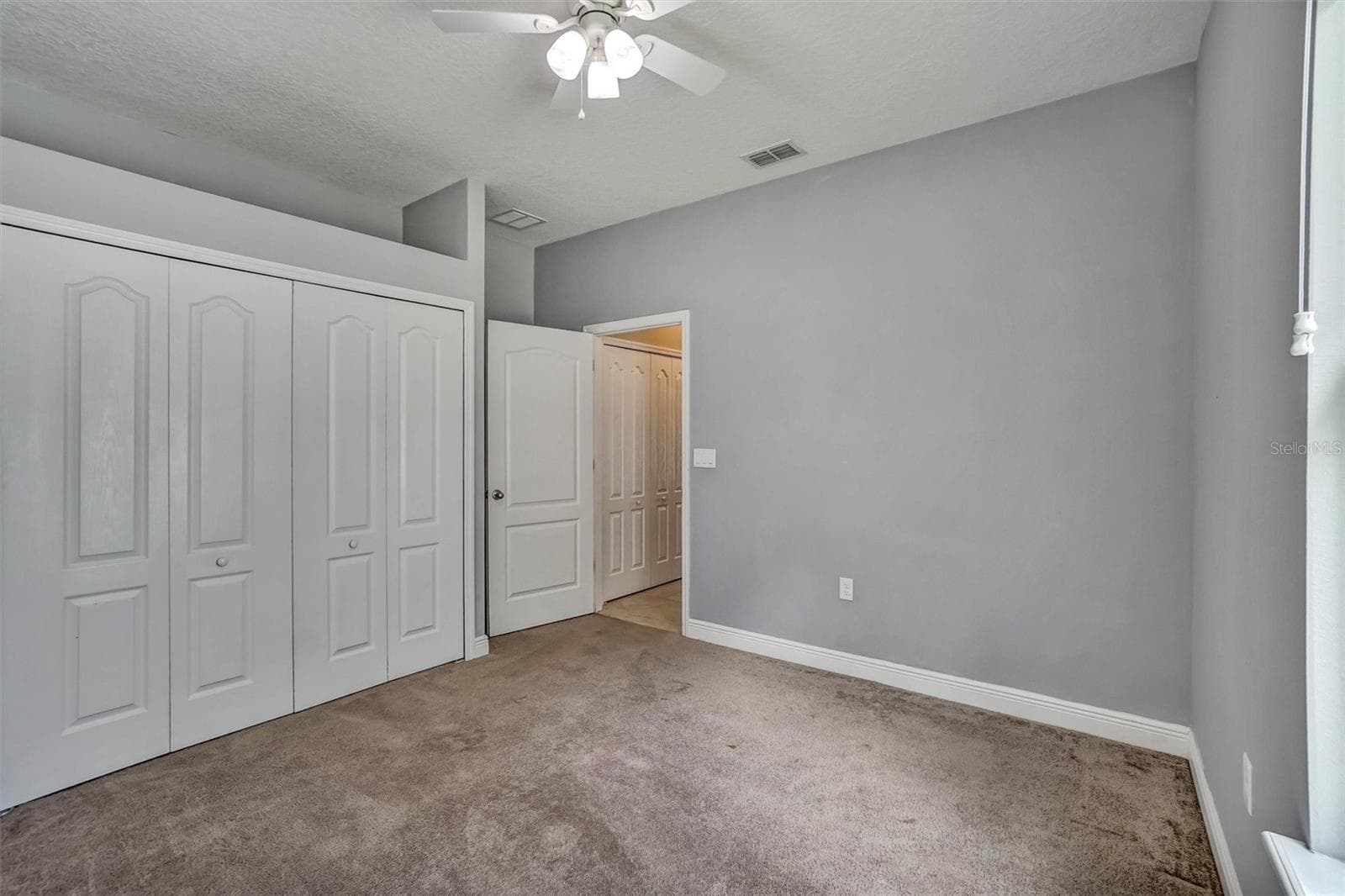 Bedroom viewFourth bedroom with a clean layout and convenient closet access. - 1720 LADY FERN TRL, DELAND