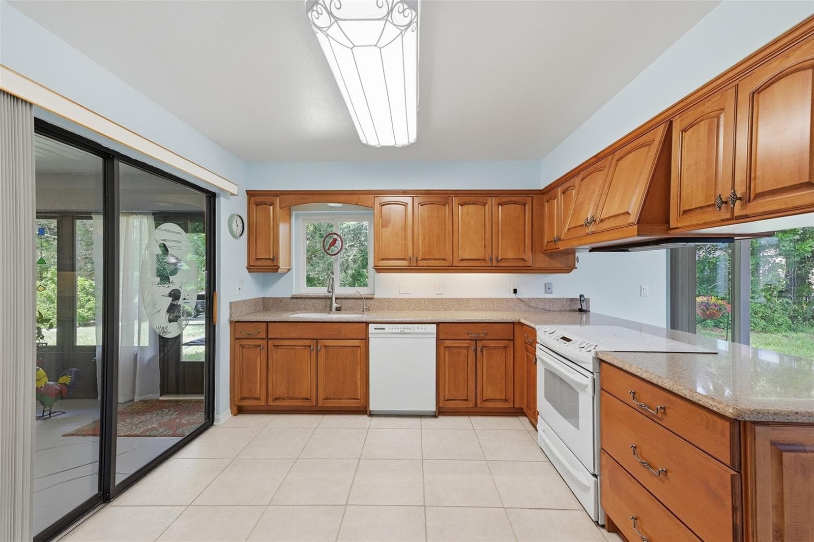 UPDATED SPACIOUS KITCHEN WITH WOOD CABINETS, SOLID SURFACE COUJTER TOPS, SLIDE IN RANGE WITH CUSTOM HOOD. - 1803 NEW BEDFORD DR, SUN CITY CENTER