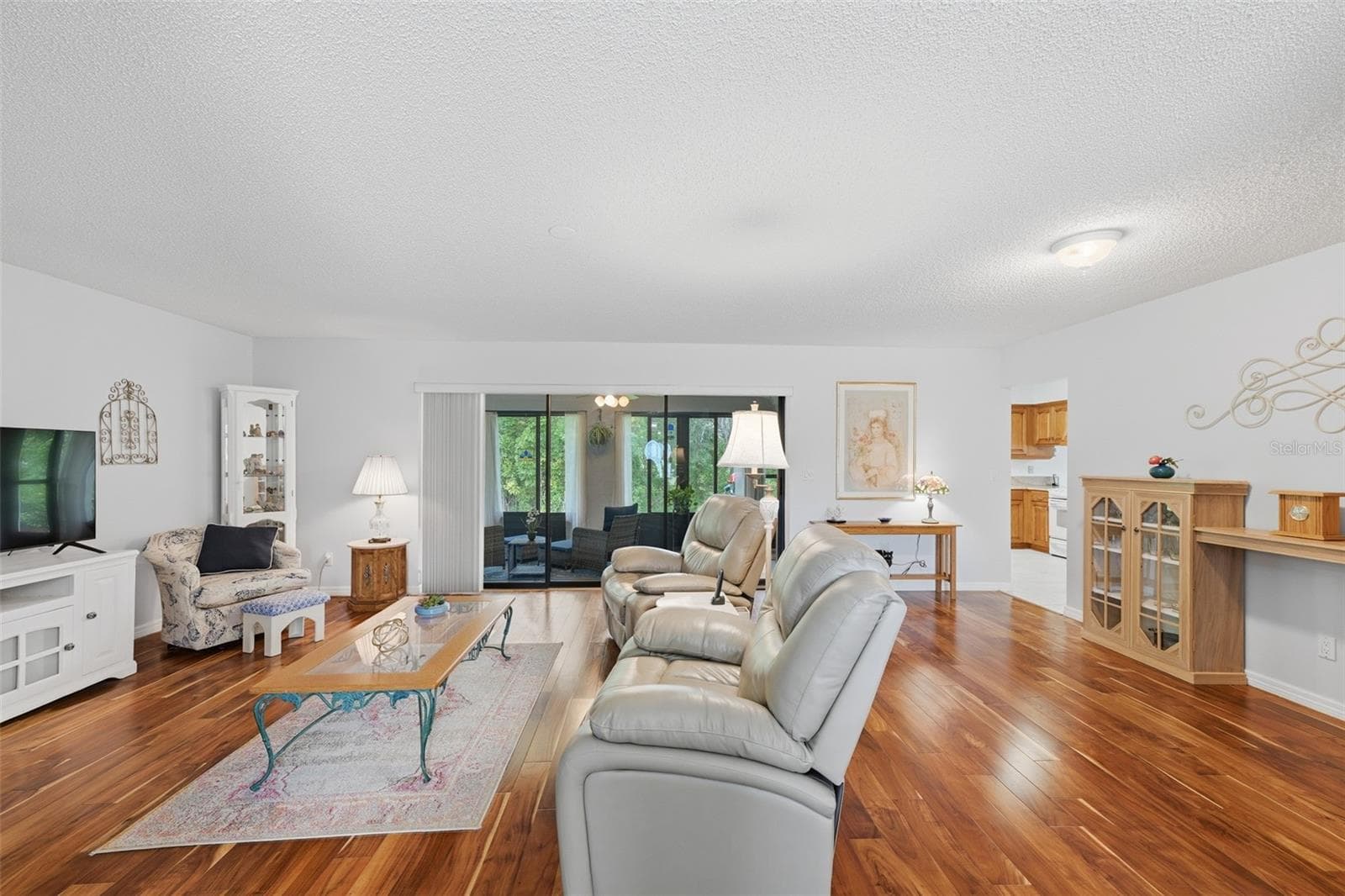 GREAT ROOM LOOKING OUT TO THE GLASS ENCLOSED LANAI AND WOODS. - 1803 NEW BEDFORD DR, SUN CITY CENTER