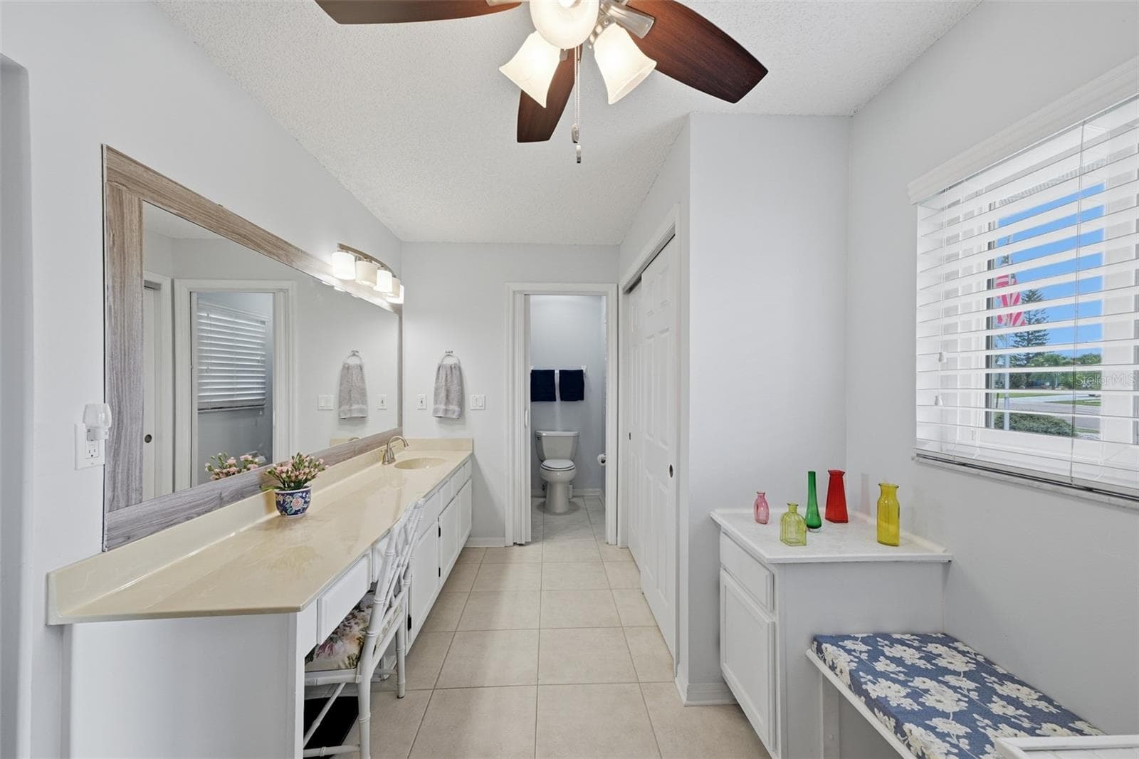 MAIN BATHROOM WITH LARGE VANITY AND PLACE TO SIT DOWN AND PUT YOUR SHOES ON AND EXTRA CLOSET. - 1803 NEW BEDFORD DR, SUN CITY CENTER