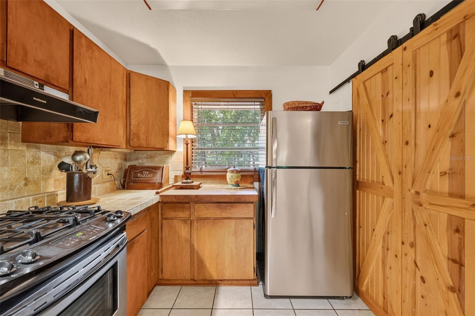 Close up view featuring sliding pantry door and tiled backsplash - 24939 OLD DEER RD, PAISLEY
