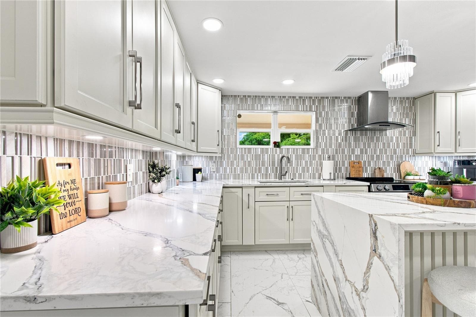 Quartz waterfall edge creates a visual stop in the kitchen area that works elegantly with upscale cabinetry, and backsplash. - 9020 AUBURN WAY, TAMPA