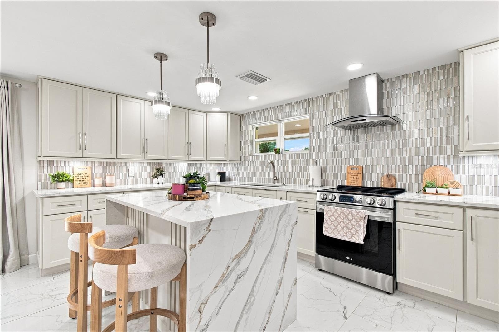 Quartz waterfall edge creates a visual stop in the kitchen area that works elegantly with upscale cabinetry, and backsplash. - 9020 AUBURN WAY, TAMPA