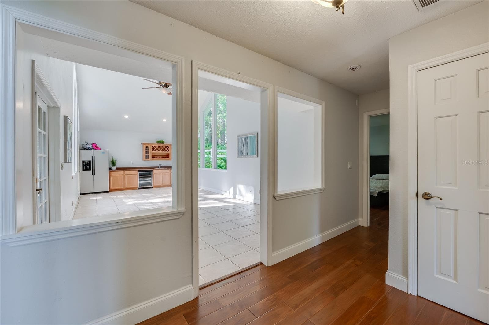 Entryway showcase featuring rich laminate flooring that opens into a bright, tiled interior flex space. - 2081 PENNSYLVANIA DR, DELAND