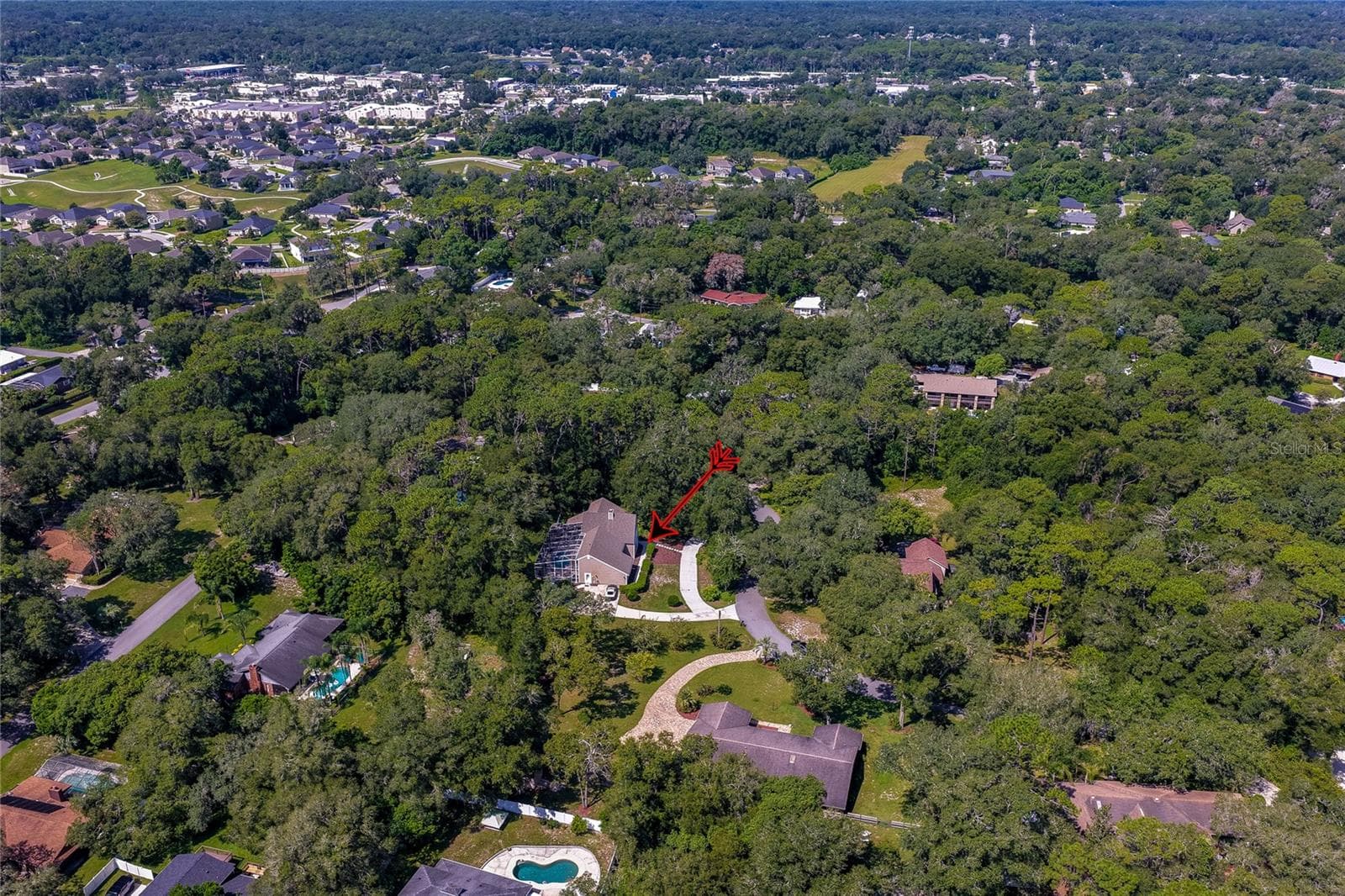 Wide aerial panorama pointing out the home nestled in a quiet, heavily wooded community setting. - 2081 PENNSYLVANIA DR, DELAND