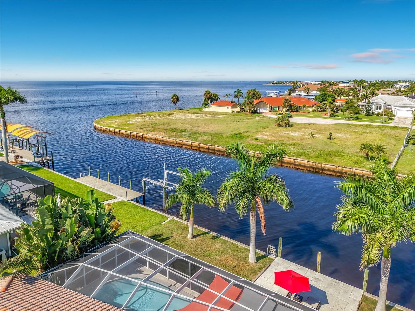 Aerial Waterfront View – Elevated aerial view highlighting the property's canal-front location and proximity to expansive open water. - 4449 CREWS CT, PORT CHARLOTTE