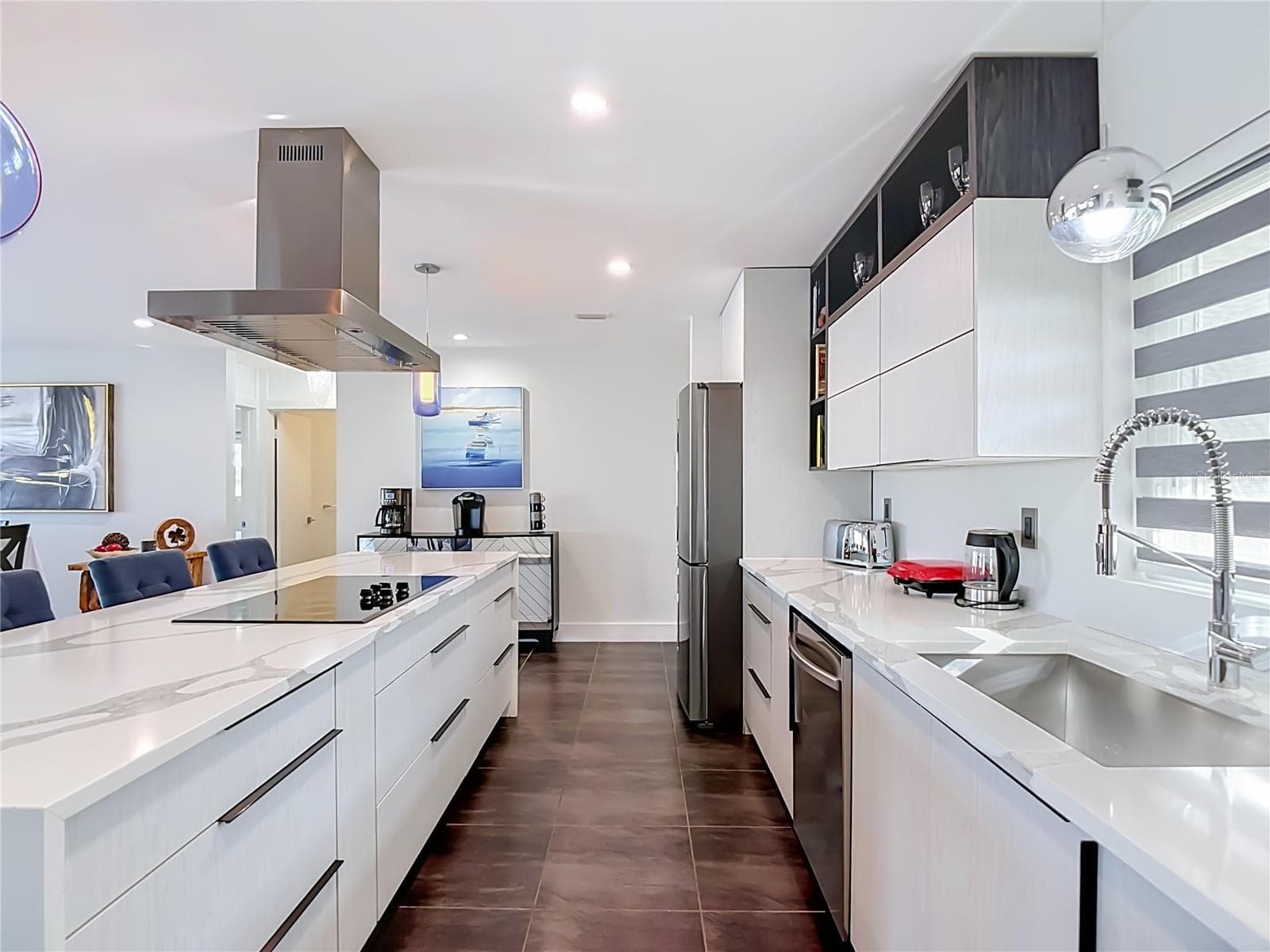 Kitchen Detail – Stylish kitchen with white cabinetry, stainless-steel appliances, range hood, and generous preparation and storage space. - 4449 CREWS CT, PORT CHARLOTTE