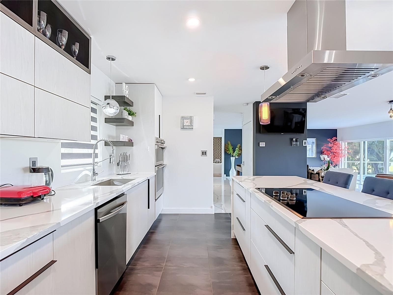 Kitchen View – Additional view of the contemporary kitchen highlighting the streamlined cabinetry, countertops, appliances, and open design. - 4449 CREWS CT, PORT CHARLOTTE