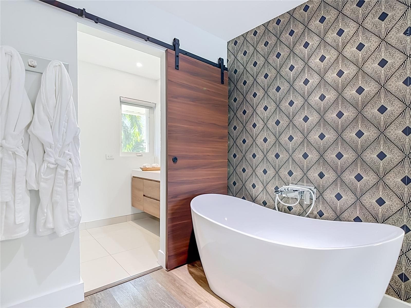 Primary Bathroom – Contemporary bathroom featuring a freestanding soaking tub, distinctive accent wall, and modern finishes. - 4449 CREWS CT, PORT CHARLOTTE