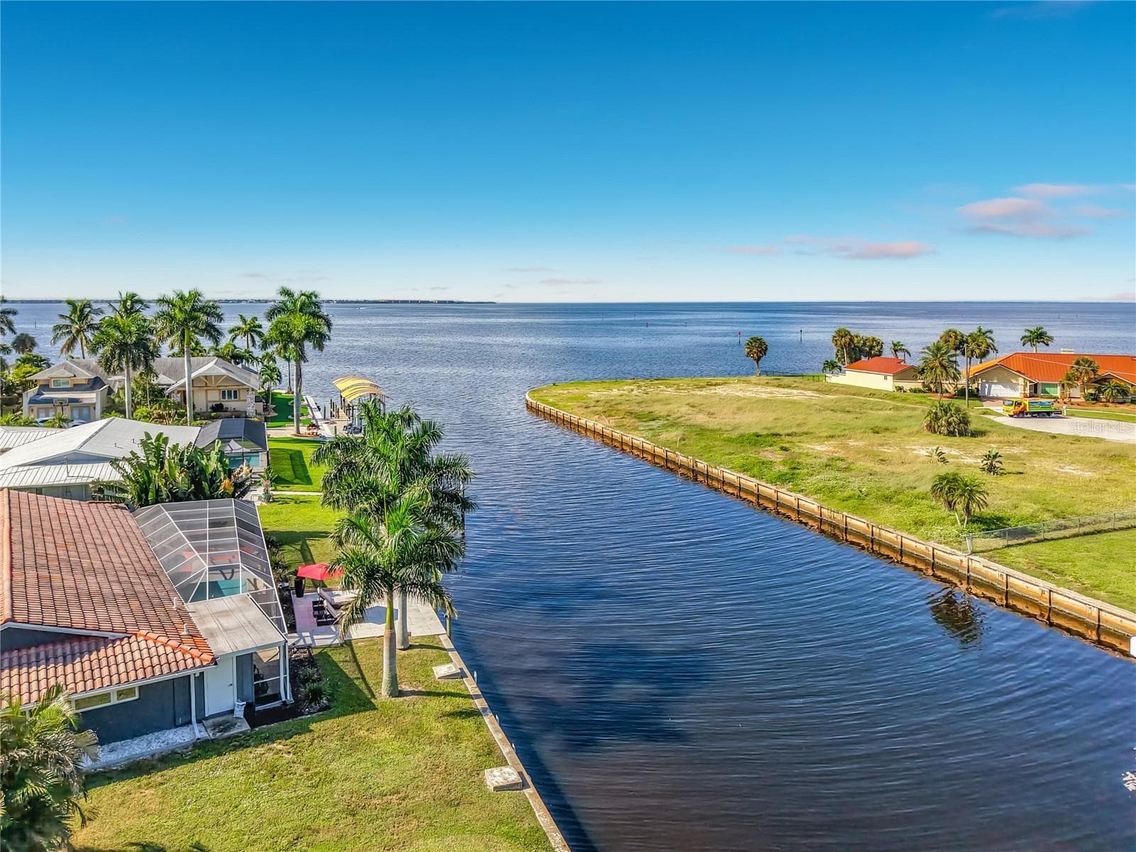 Aerial Canal View – Aerial perspective highlighting the property's waterfront position along the canal and surrounding coastal setting. - 4449 CREWS CT, PORT CHARLOTTE