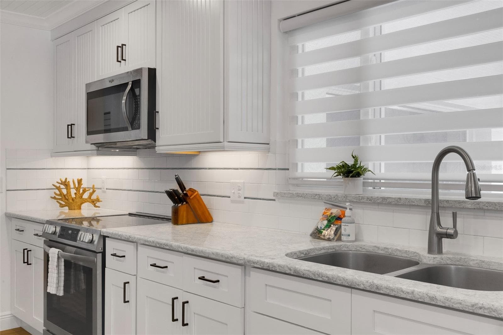 Updated kitchen features sleek cabinetry, stainless-steel range and contemporary backsplash. - 18317 SUNSET BLVD, REDINGTON SHORES