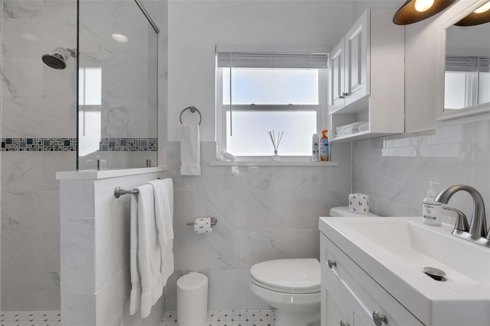 Renovated primary bath features bright contemporary finishes and a glass-enclosed shower. - 18317 SUNSET BLVD, REDINGTON SHORES