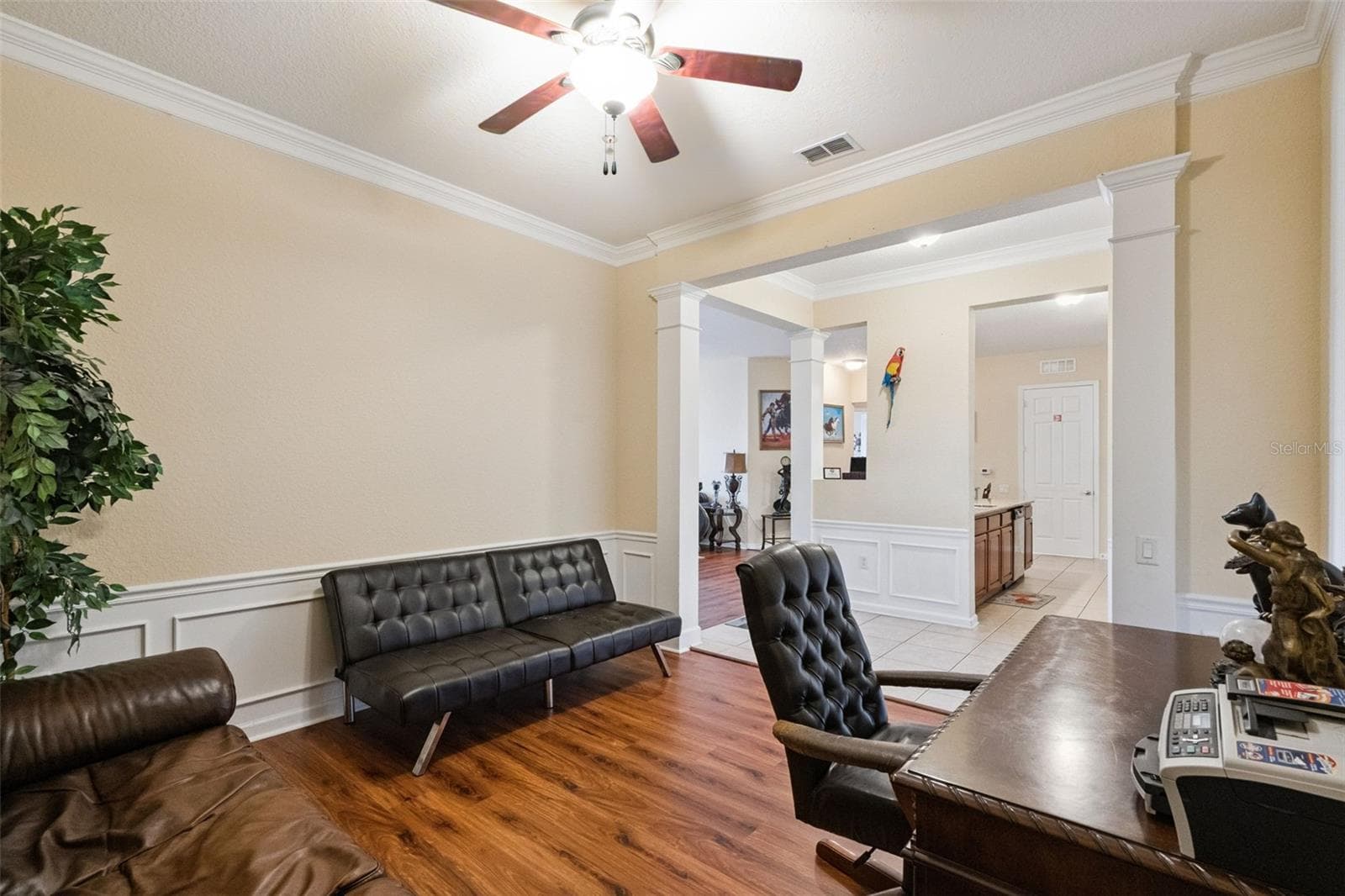 Office / Flex Room:Versatile flex room off the entryway offering warm wood-look flooring, a ceiling fan, wainscoting, and open columned archways. - 4840 CAYVIEW AVE #405, ORLANDO