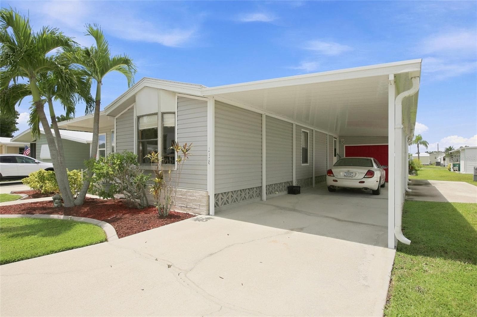Parking under carport with garage and stairway entrance into home - 238 EGRET, PUNTA GORDA