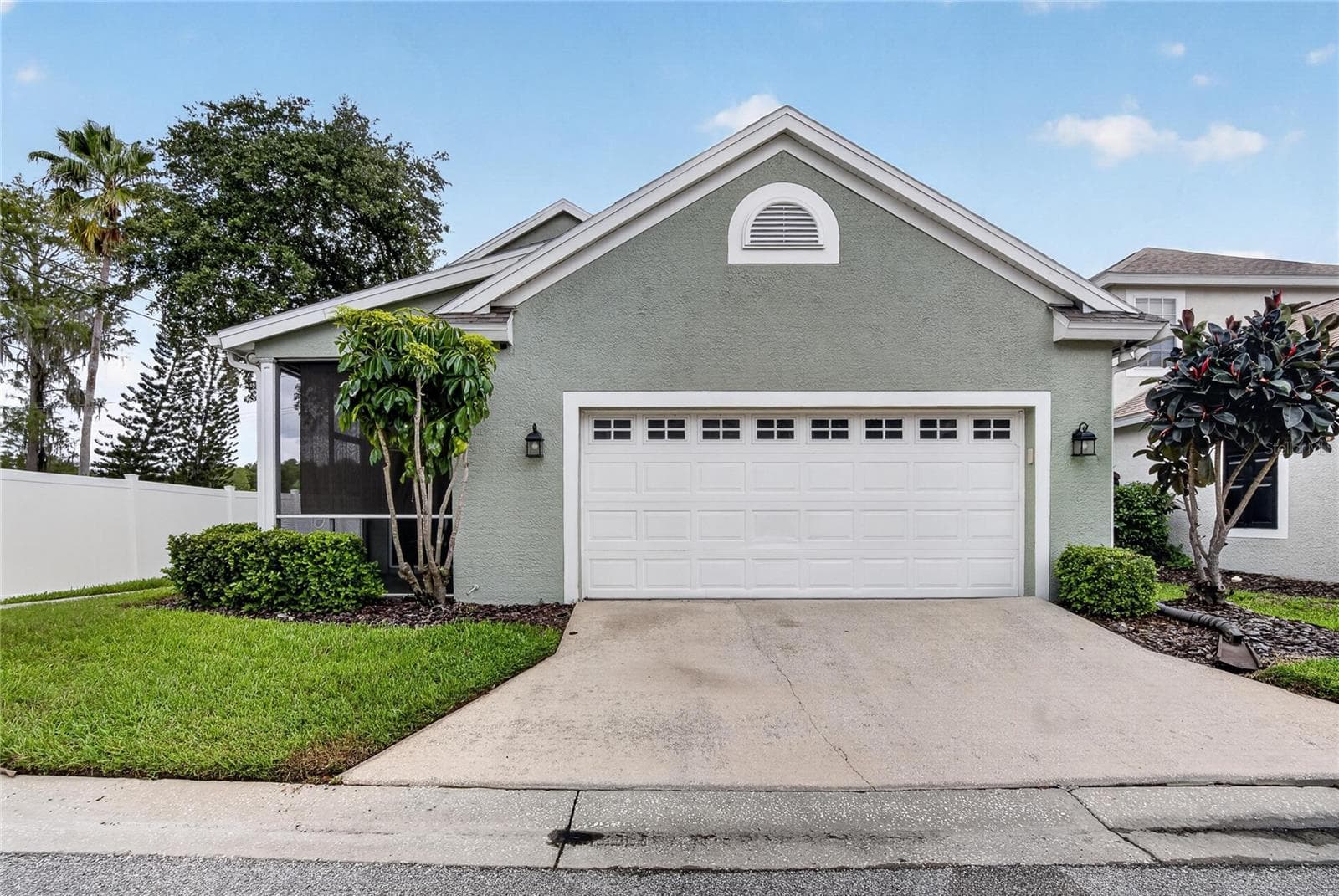 Rear-load two-car garage with screened lanai conveniently tucked alongside the home. - 10807 SIERRA VISTA PL, TAMPA
