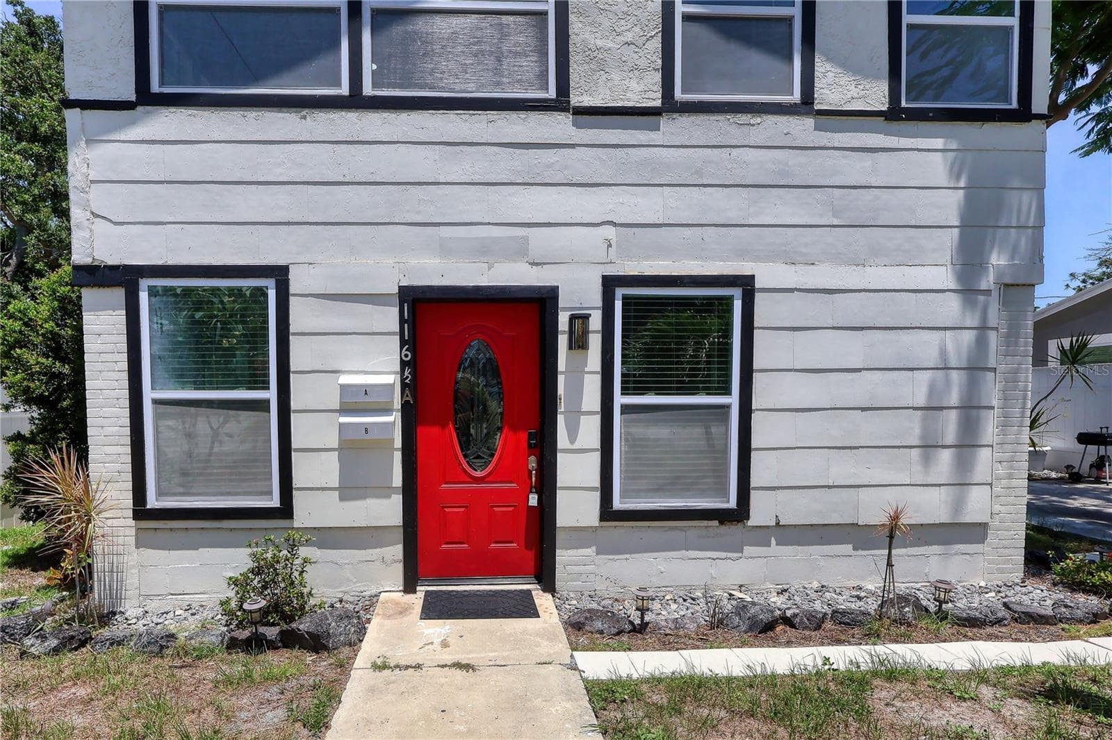 Unit A is upstairs, and Unit B is downstairs.The front door marked “A” is at ground level, it serves as the private entrance leading upstairs to Unit A. - 116 44TH ST S, ST PETERSBURG