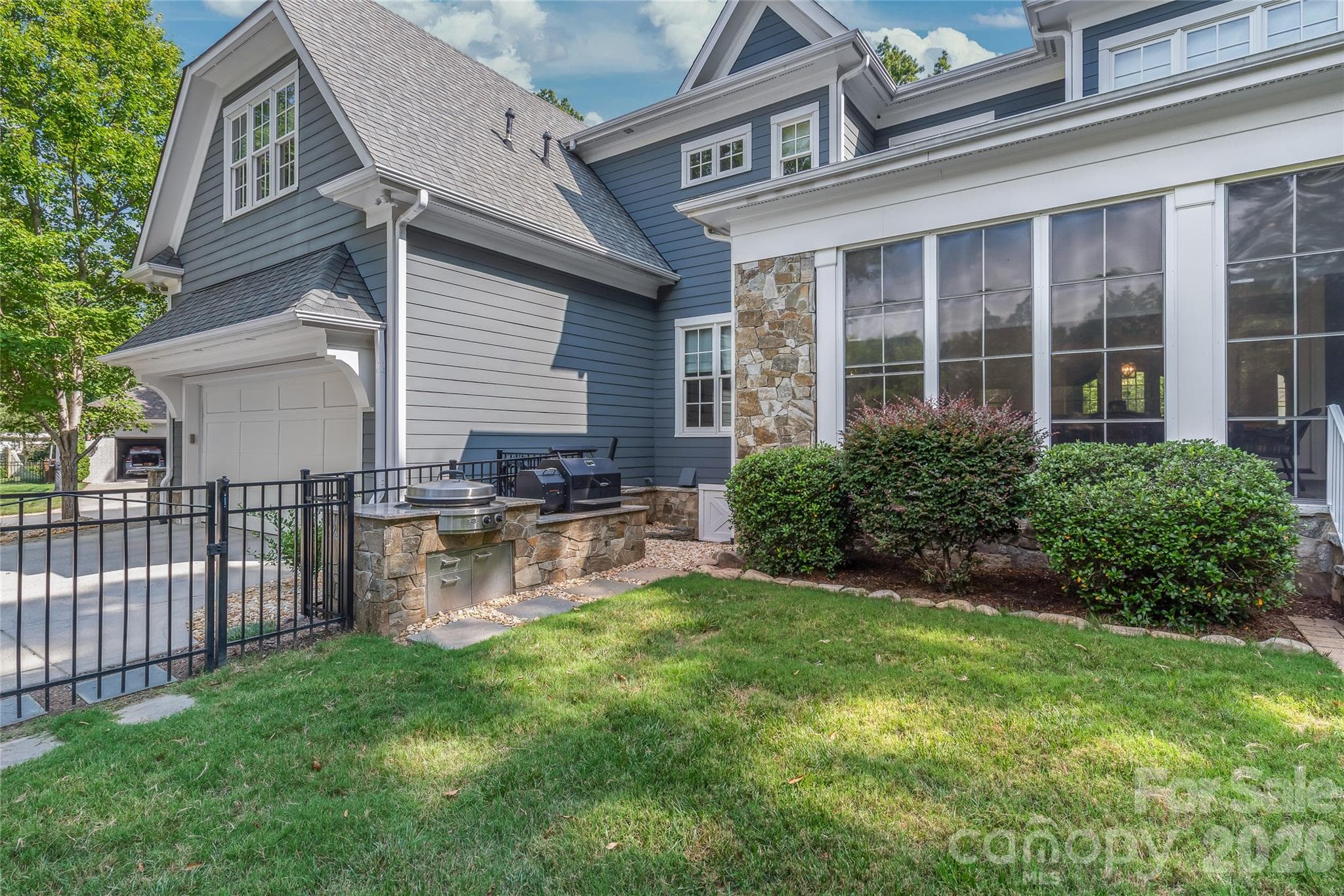 This outdoor cooking area, designed by Charlotte Grill, features an EVO grill and Yoder smoker - 2800 Wintergreen Drive, Charlotte