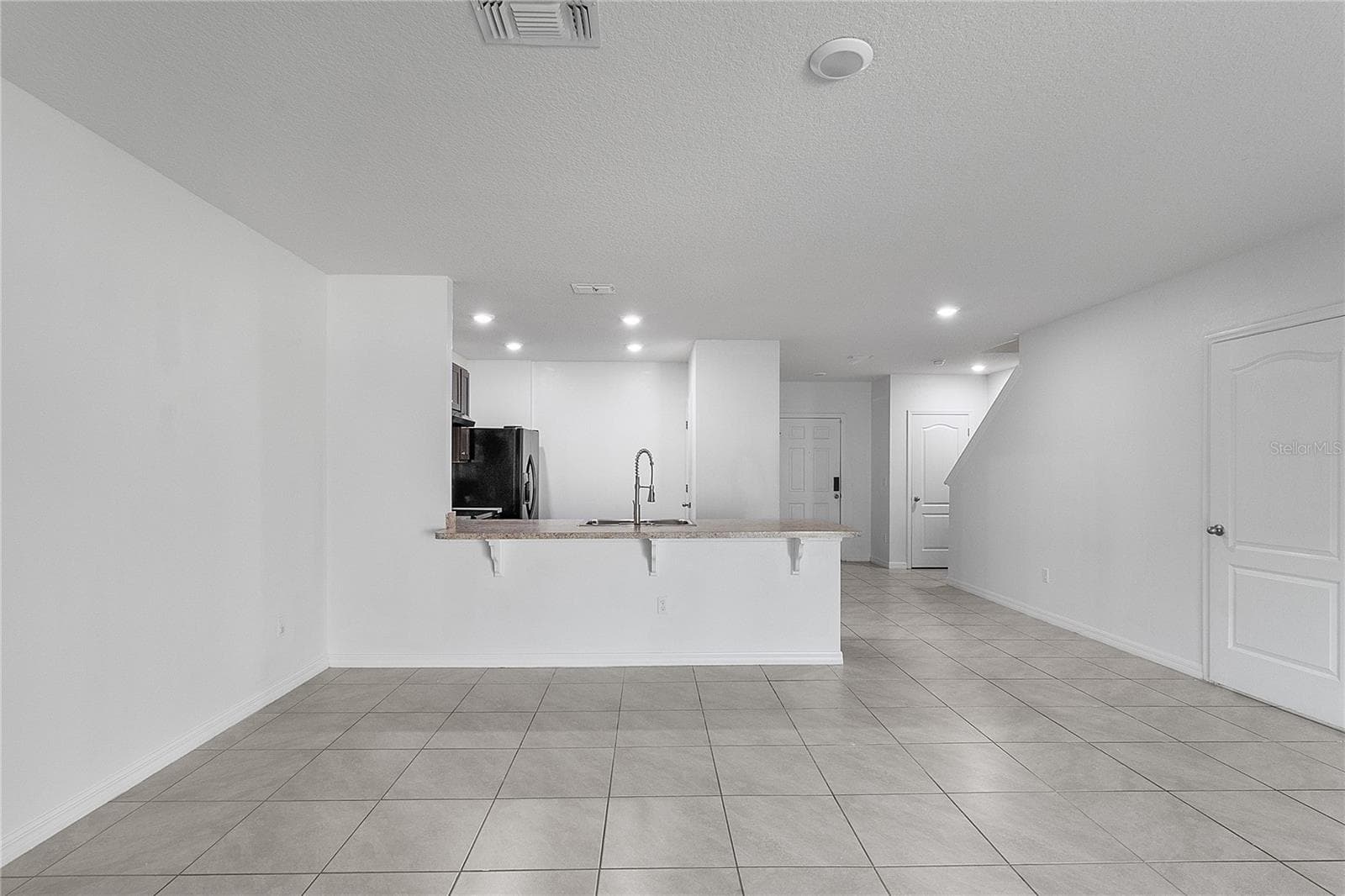 Looking at kitchen and front door - 9033 WILDFLOWER LN, KISSIMMEE