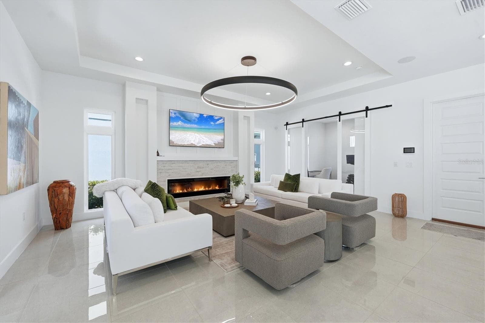 family room with electric fireplace and stone wall accent - 5935 REDBAY BLVD, BRADENTON