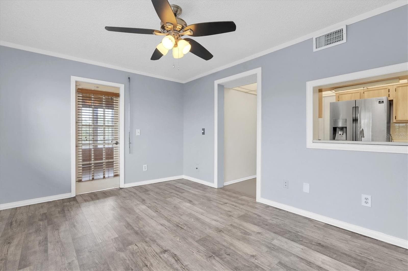 Family room/den with the kitchen passthrough, kitchen doorway, and an additional door to the all season patio - 8198 TERRACE GARDEN DR #511, ST PETERSBURG
