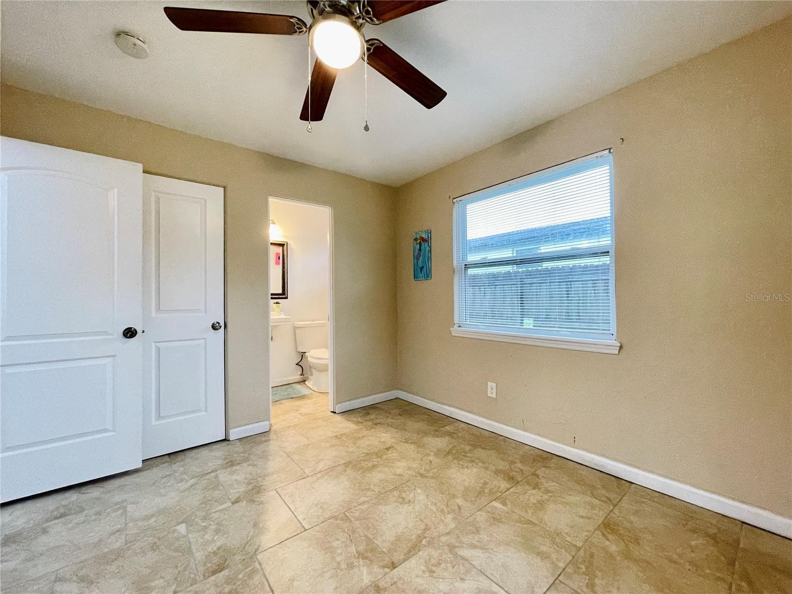 Another view of the bright bedroom with neutral colors and ceiling fan. - 723 STEELE AVE, SOUTH DAYTONA