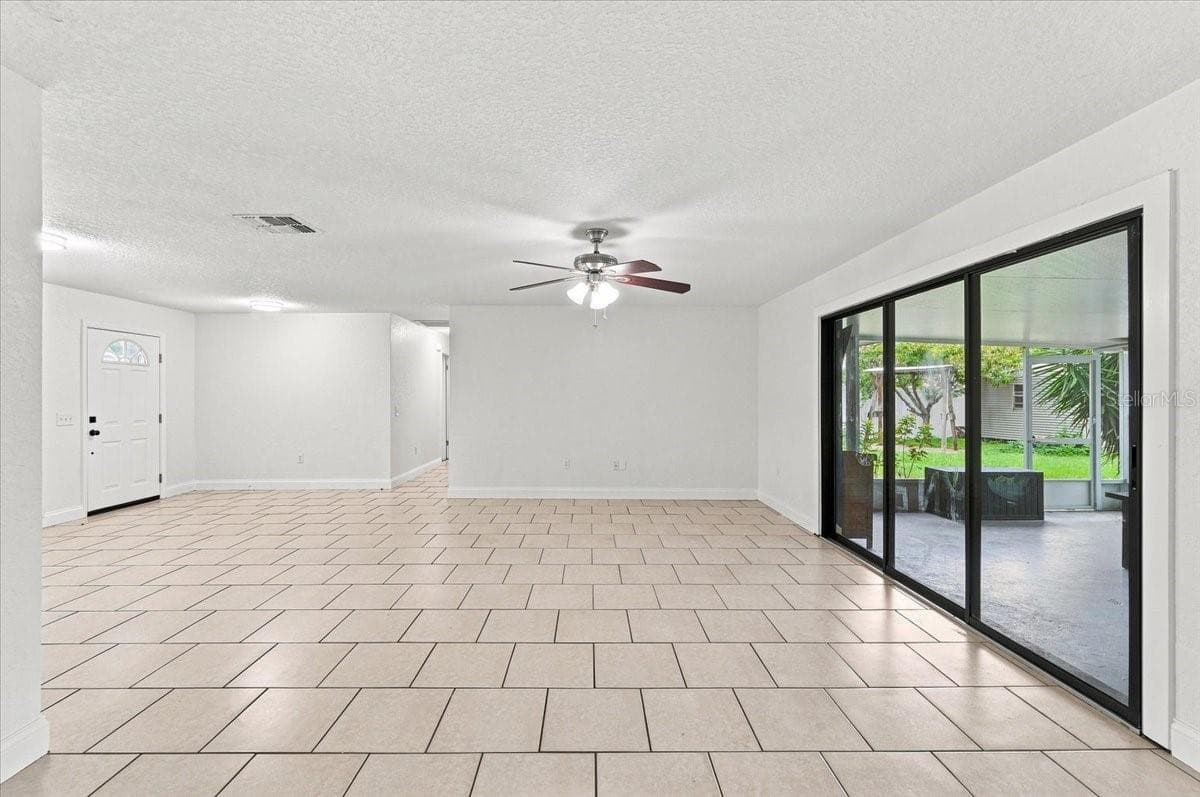 Living room and sliding door to back screened lanai - 121 LOWELL RD, WINTER HAVEN