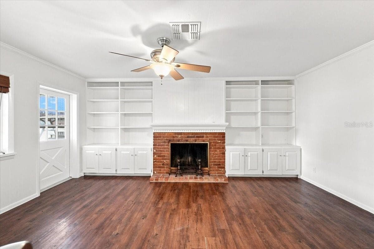 Family room with wood burning fireplace and entry to back screened lanai - 121 LOWELL RD, WINTER HAVEN