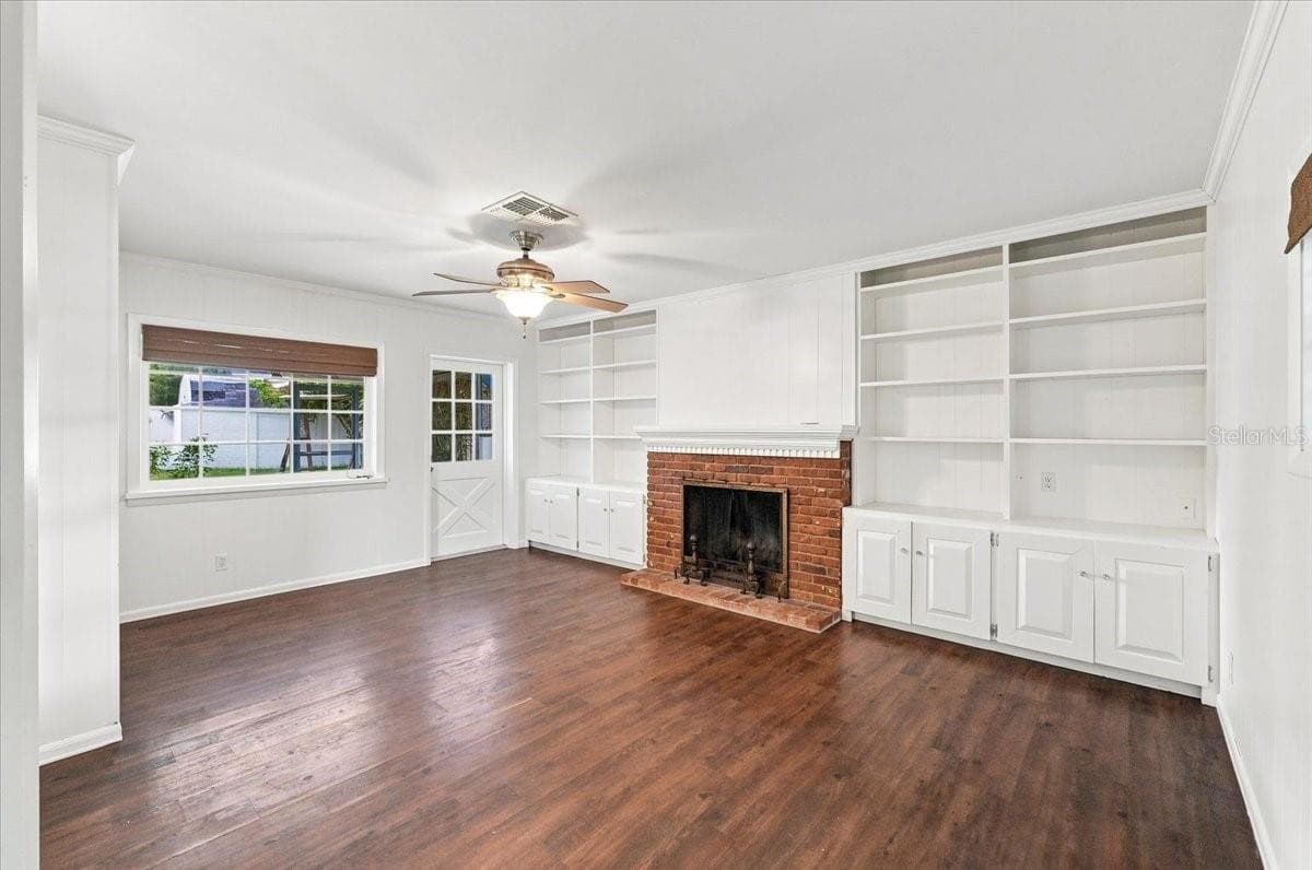 Family room with wood burning fireplace and entry to back screened lanai - 121 LOWELL RD, WINTER HAVEN