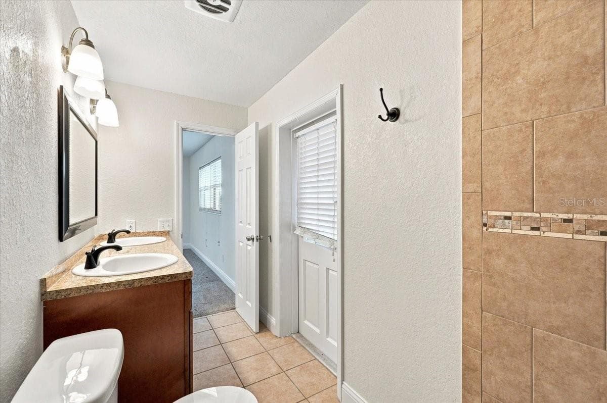 Primary bathroom with entry to back screened lanai - 121 LOWELL RD, WINTER HAVEN