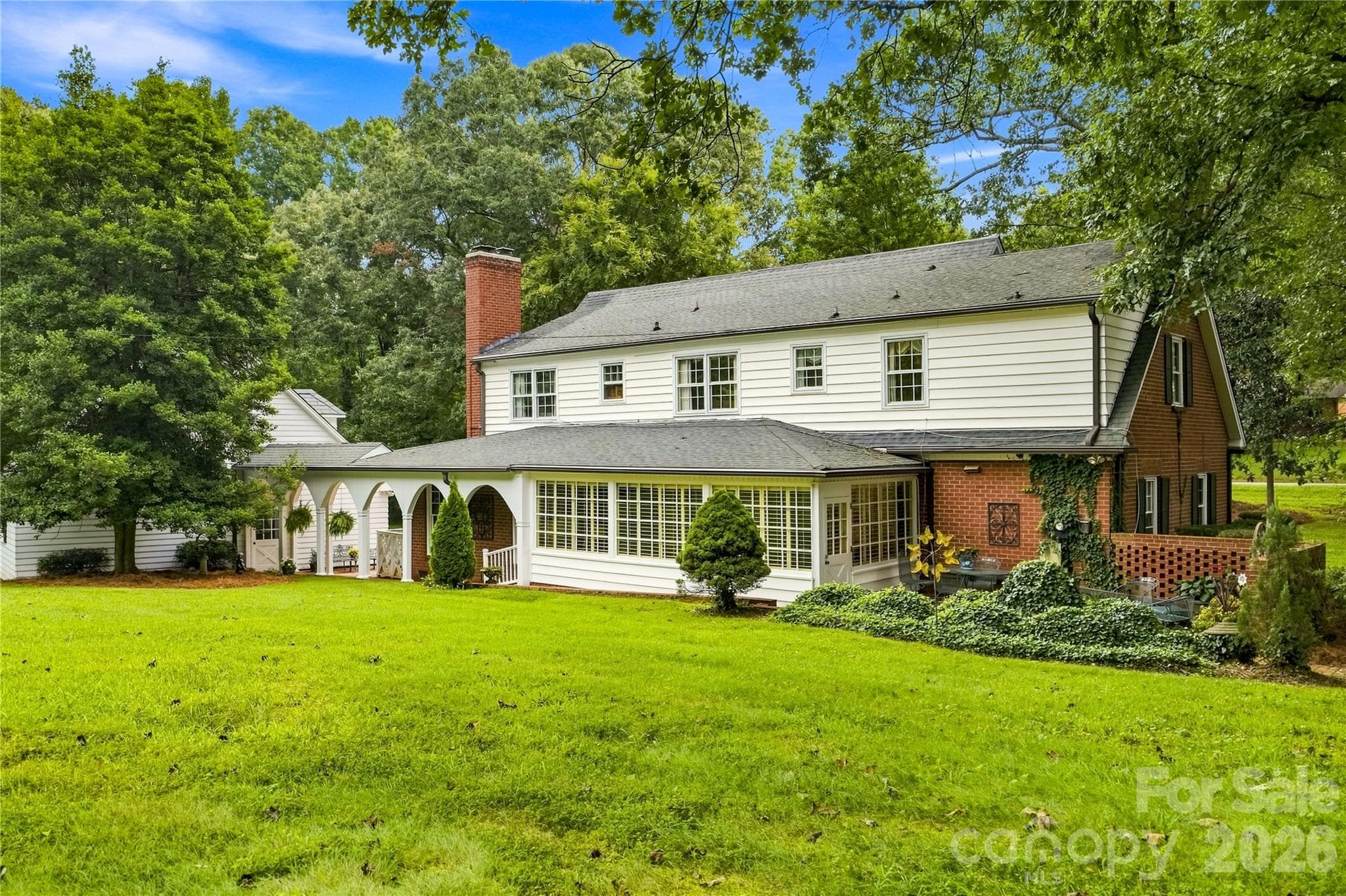 Rear view highlighting the sunroom, brick patio and covered breezeway. - 209 Labans Lane, Lincolnton