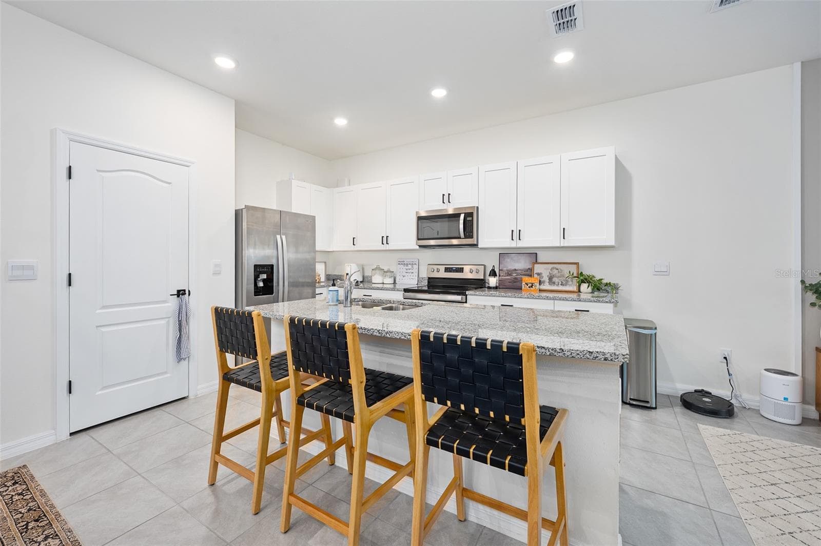 Island with barstool seating, pantry door - 166 REENA DR, DAYTONA BEACH