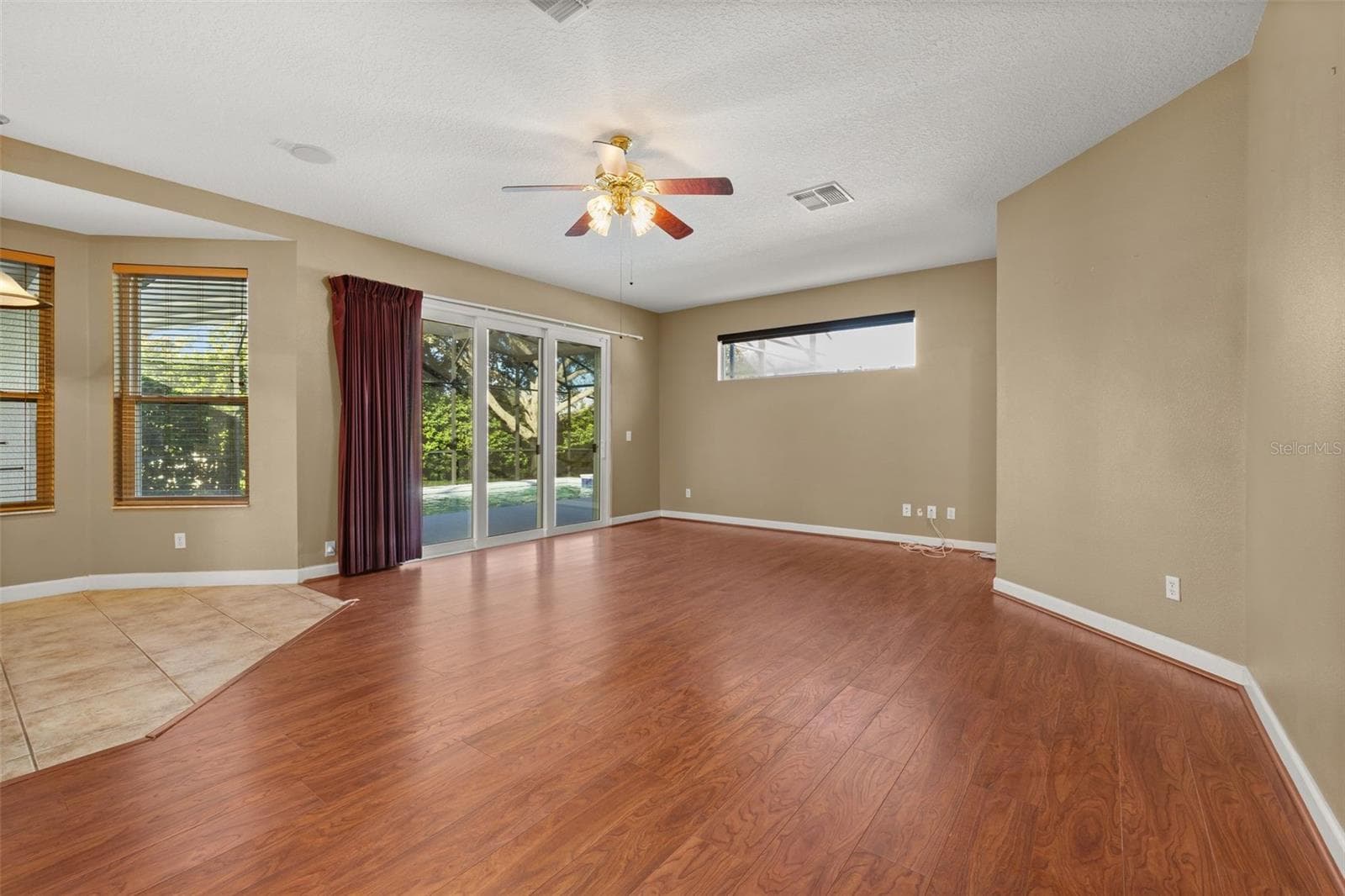 Casual open living space overlooking the pool from a wall of sliding glass doors - 2039 HARBOR COVE WAY, WINTER GARDEN