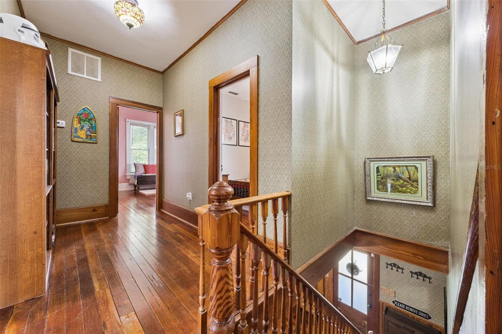 Upstairs, original floors and millwork continue through a spacious central landing connecting the bedroom wing. - 2201 CELERY AVE, SANFORD