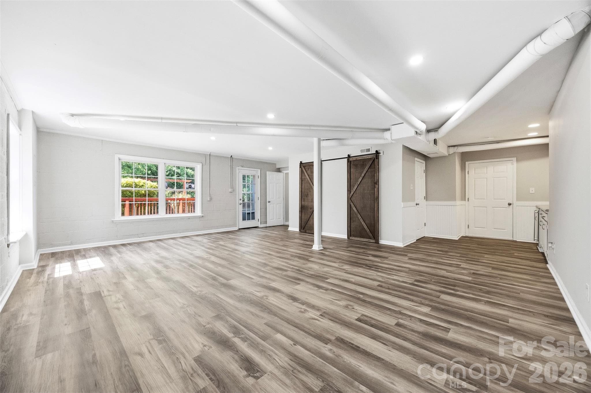 2nd look basement level showing how large the space is and the 2 sliding barn doors which are 2 closets. This space has a full bath, a door and windows and can be used in many ways such as a guest suite, office, play room, home theater, home gym and more. - 6506 Candlewood Drive, Charlotte