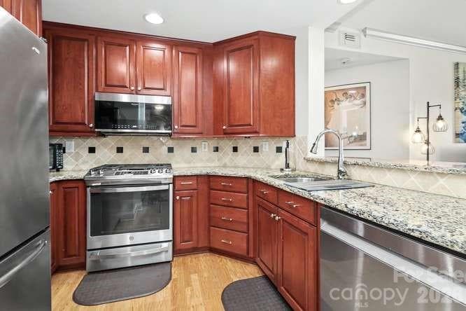 All recently replaced stainless steel appliances including gas cooktop and convection oven. Granite countertops complement the transitional decor. - 401 N Church Street, Charlotte