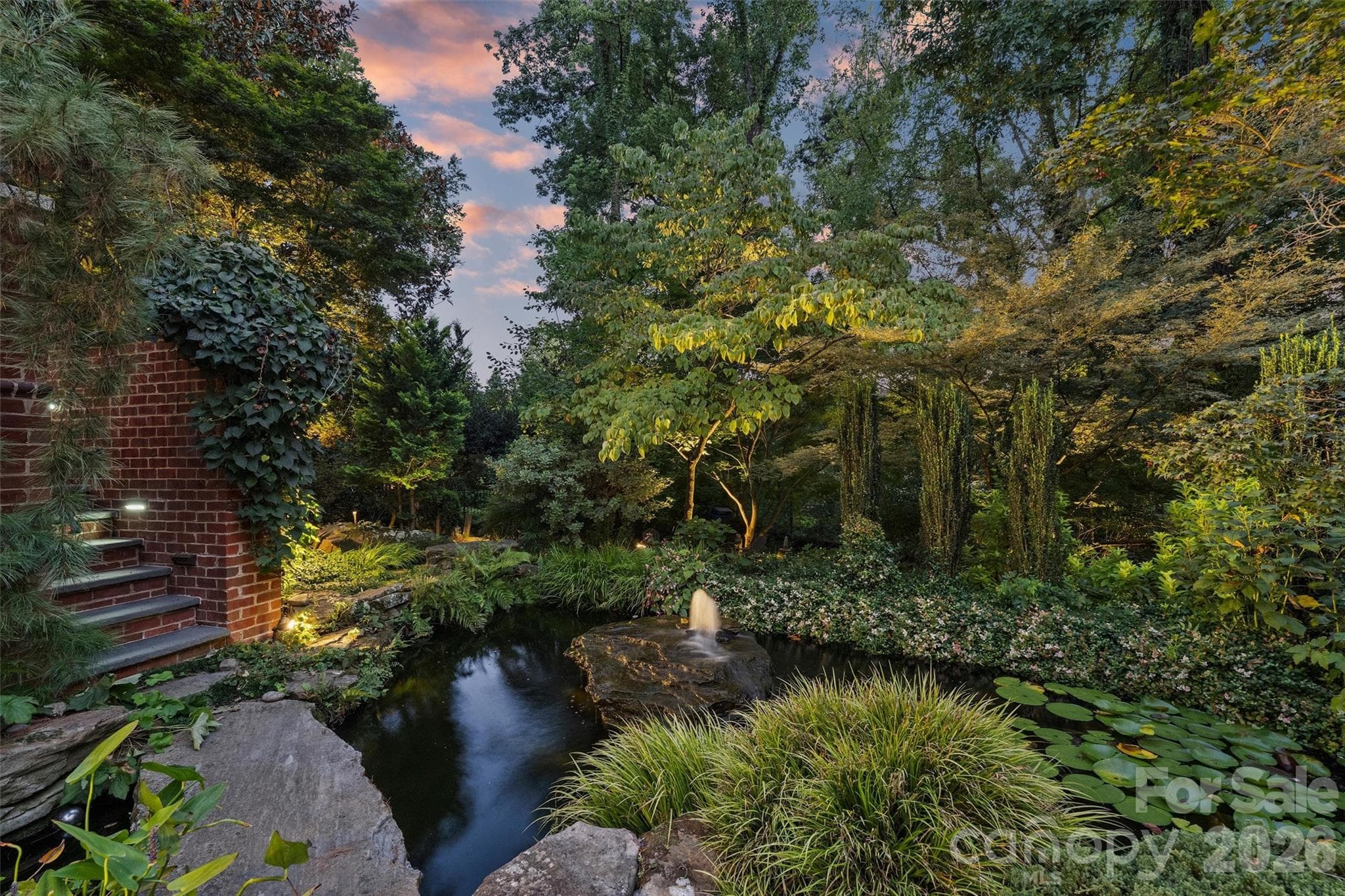 Koi pond at twilight with landscape lighting. - 2115 Foxcroft Woods Lane, Charlotte