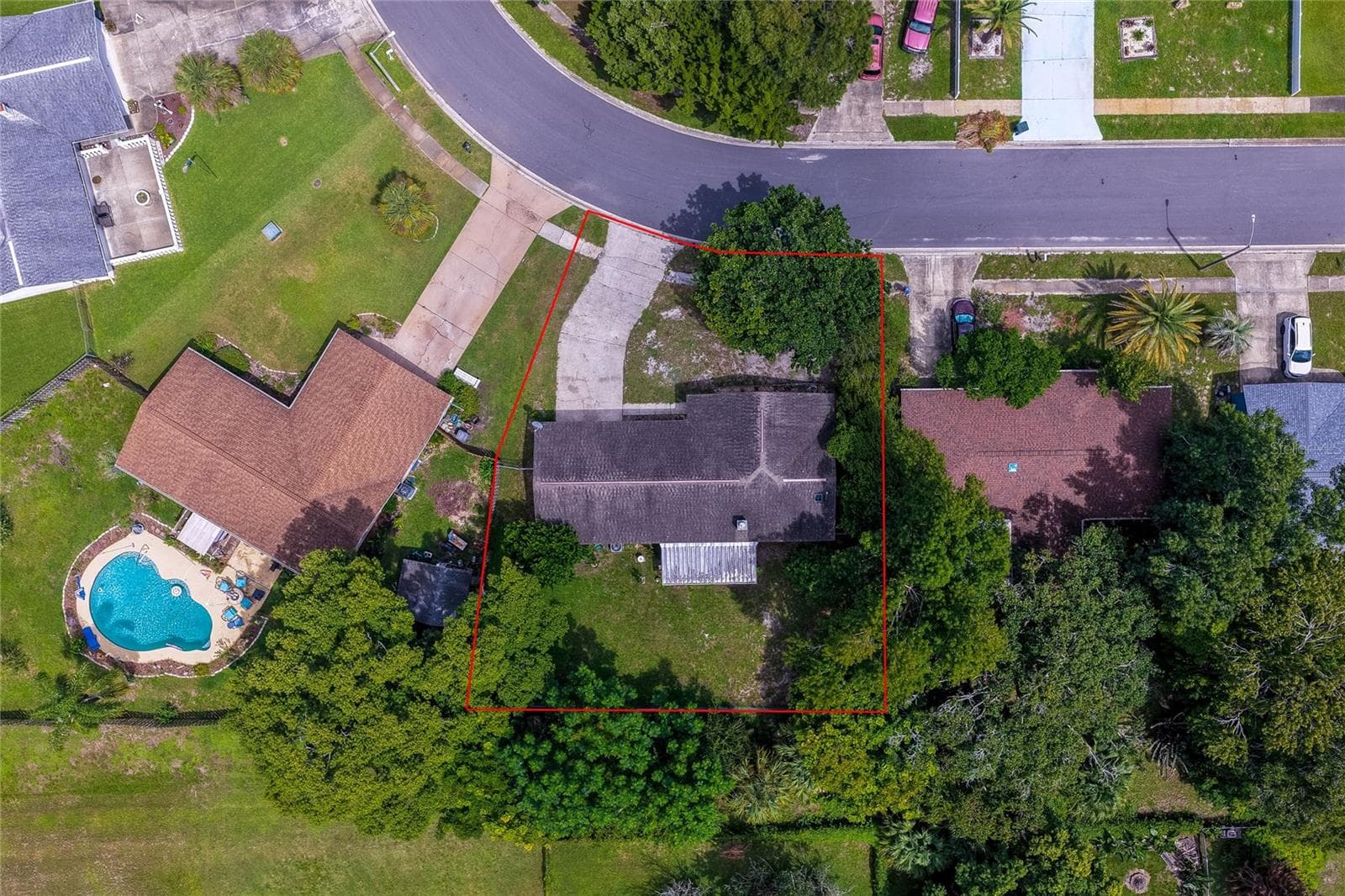 Direct overhead aerial view displaying the property boundaries outlined in red, including the house roof, driveway, screened porch, and yard. - 146 WESTWOOD DR, DAYTONA BEACH