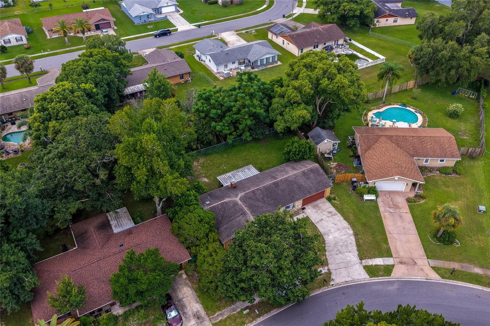 Close aerial view highlighting the home, surrounding tree canopy, driveway layout, and adjacent properties. - 146 WESTWOOD DR, DAYTONA BEACH
