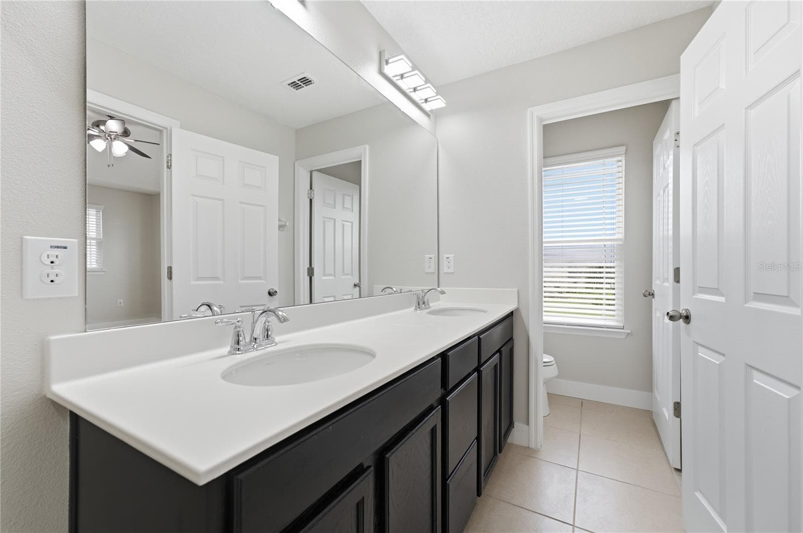 Private primary bathroom featuring a spacious dual-sink vanity and separate water closet. - 2615 GIARDINO LOOP, KISSIMMEE